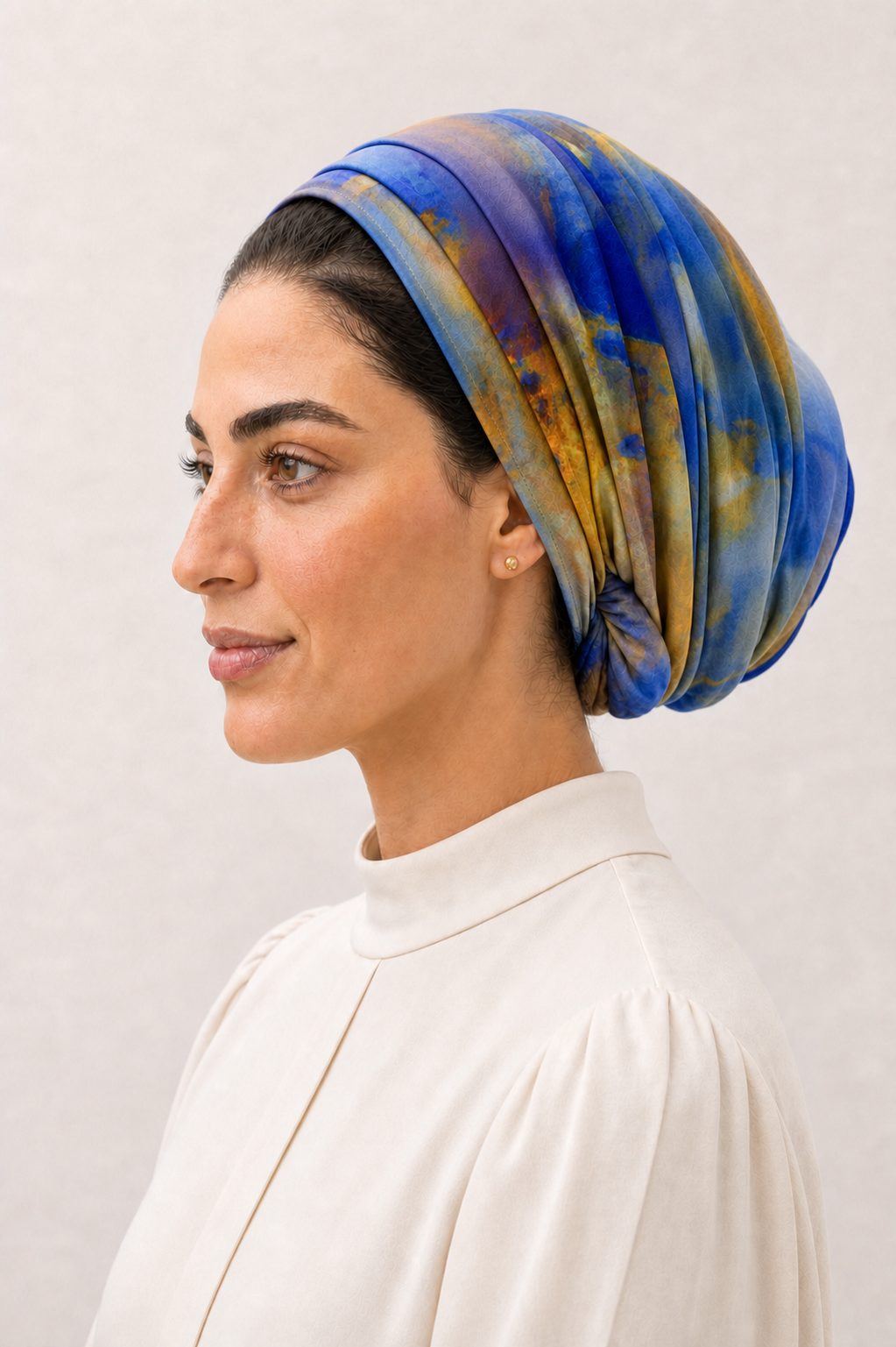 Three-quarter portrait in a blue, gold and violet headscarf